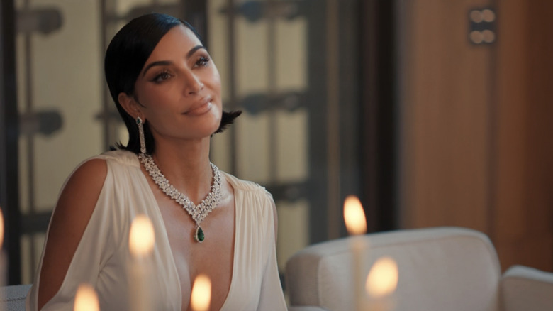 Kim Kardashian's Allura smiles as she sits at a table in All's Fair