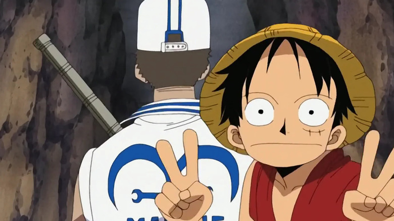 Luffy looks deadpan at the camera with his hands in a V sign in One Piece