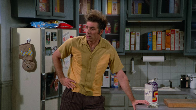 Kramer standing in Jerry's kitchen wearing a yellow shirt in Seinfeld