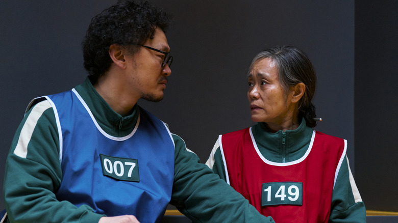 Yang Dong-geun as Yong-sik and Kang Ae-shim as Geum-ja wearing colorful vests on Squid Game
