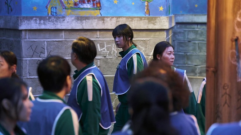 Park Sung-hoon as Cho Hyun-ju wearing a blue vest on Squid Game