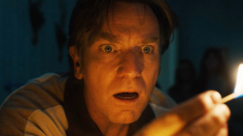 Ewan McGregor's Greg Platt is seen in closeup as he holds a lit match in The End of Oak Street