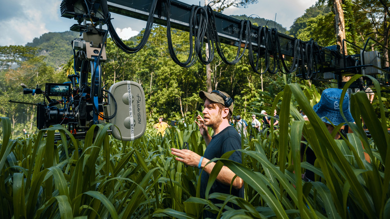 Gareth Edwards directing a scene set amid a field of long grass on the set of Jurassic World Rebirth