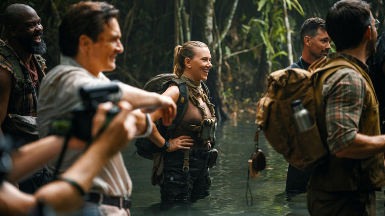 Actors Bechir Sylvain as LeClerc, Rupert Friend as Martin Krebs, Scarlett Johansson as Zora Bennett, and Jonathan Bailey as Henry Loomis standing in water in a behind-the-scenes still from Jurassic World Rebirth