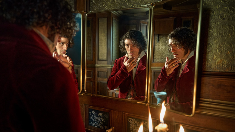 Oscar Isaac as Victor Frankenstein checking himself out in a three-part mirror in Frankenstein