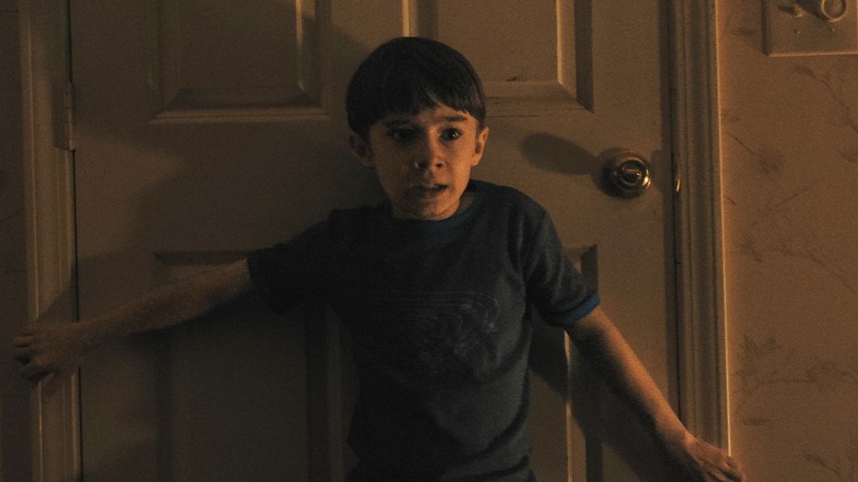 Alex holding a door shut in Weapons