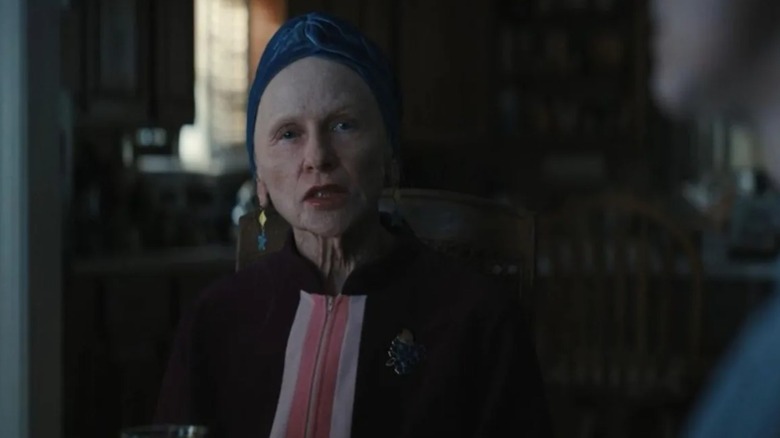 Aunt Gladys without her makeup and a turban on sitting in the dining room in Weapons