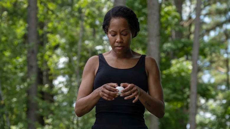Regina King as Angela Abar holding an egg outside in Watchmen (2019)