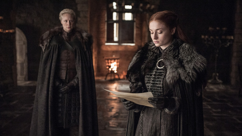 கேம் ஆஃப் த்ரோன்ஸில் ப்ரியென்னுக்கு முன்னால் பேப்பர் படிக்கும் சான்சா