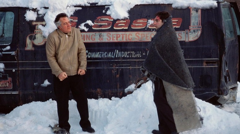 Polly and Christopher stand in the snow with bloodied faces in the film 