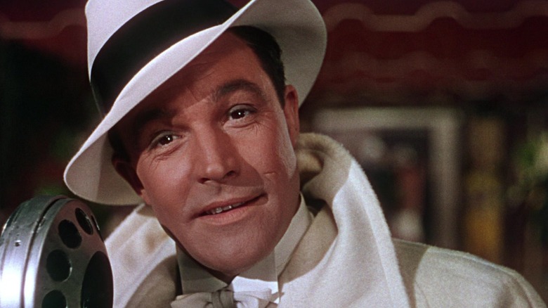 Gene Kelly as Donald Lockwood wearing a white hat and coat in Singin' in the Rain