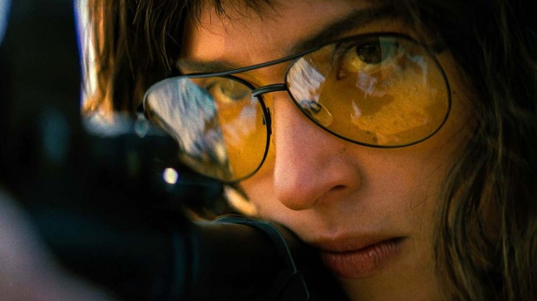 A close up of Adria Arjona as Celeste shooting her rifle in Onslaught