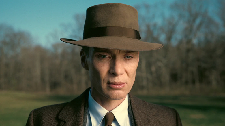 Cillian Murphy as J Robert Oppenheime standing by the pond in Oppenheimer