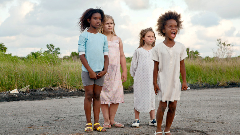 Vier meisjes, geleid door een schreeuwende Hushpuppy die op een kale weg staat in Beasts of the Southern Wild
