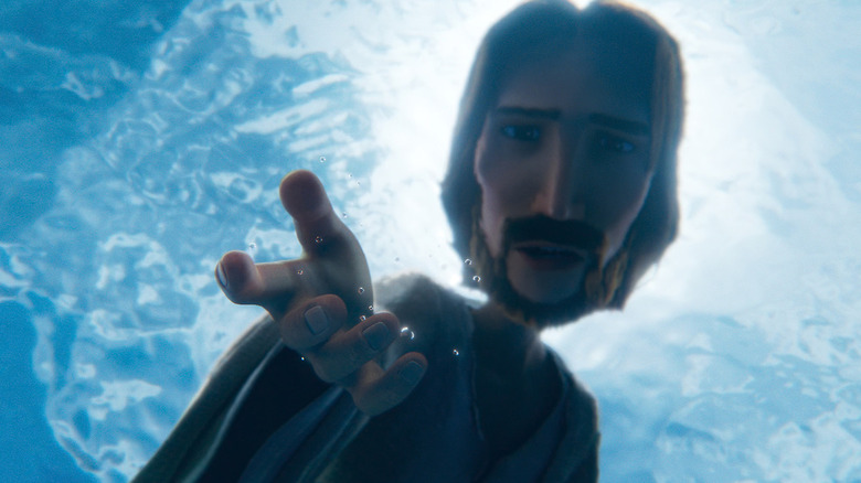 Oscar Isaac's Jesus reaching his hand into water in The King of Kings