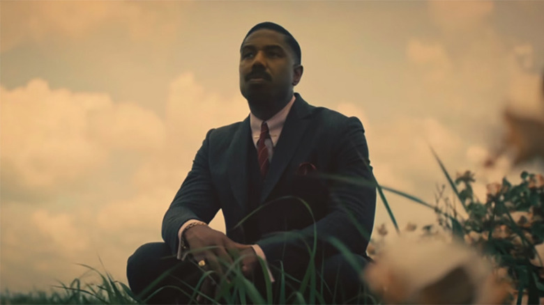 Michael B. Jordan sitting in a field in Sinners