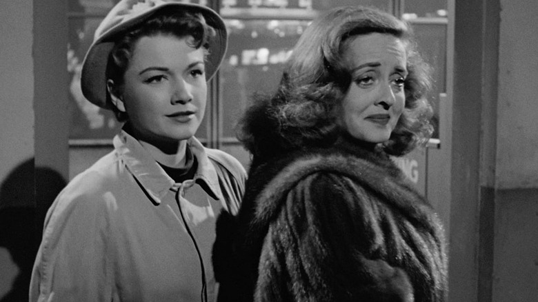 Eve Harrington and Margo Channing, about to exit a theater in All About Eve