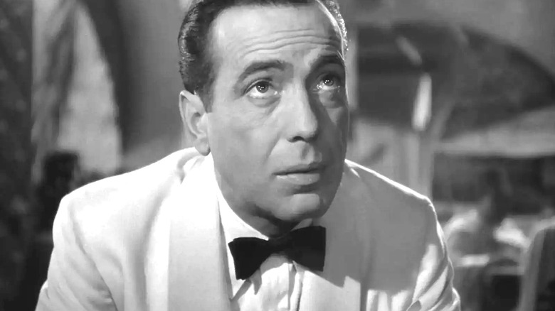 Rick outside of his cafe wearing a white suit in Casablanca