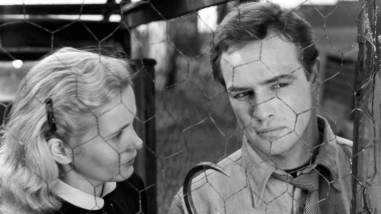 Edie and Terry behind a chicken wire fence in On the Waterfront