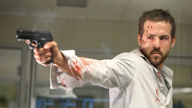 Ryan Reynolds bloody holding gun