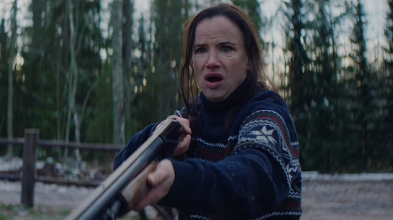 Juliette Lewis as Allegra pointing a gun, looking shocked, in Over Your Dead Body