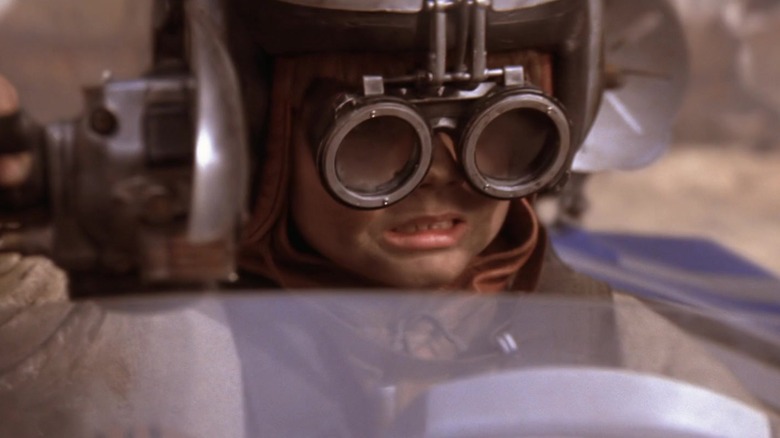 Anakin Skywalker wearing goggles and a helmet while piloting a podracer in Star Wars: The Phantom Menace