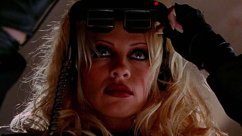 Barbara/Barb Wire Kopetski lifting glasses off her face in Barb Wire