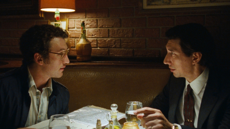Miles Teller as Irwin Pearl seated at a restaurant table opposite Adam Driver as Gary Pearl in Paper Tiger