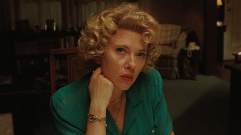 Scarlett Johansson as Hester Pearl sitting at a dinner table with a concerned expression in Paper Tiger