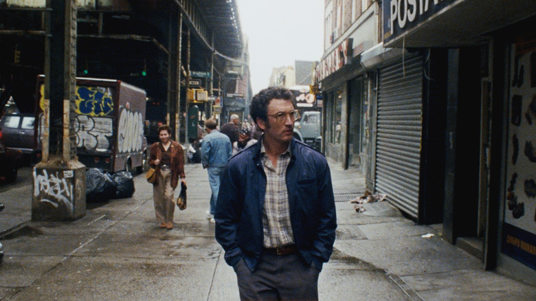 Miles Teller as Irwin Pearl walking down a New York City street in Paper Tiger