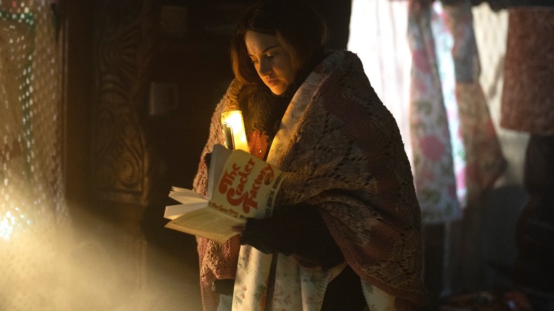 Annie reads a book inside Graceland in season 2 of Paradise