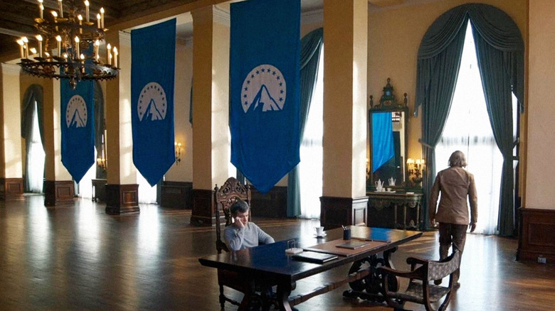 Nathan Fielder as himself sitting at a desk in a room decorated by Paramount flags in The Rehearsal