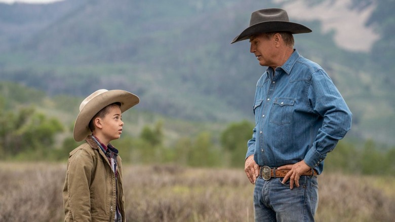 Boy and cowboy standing field