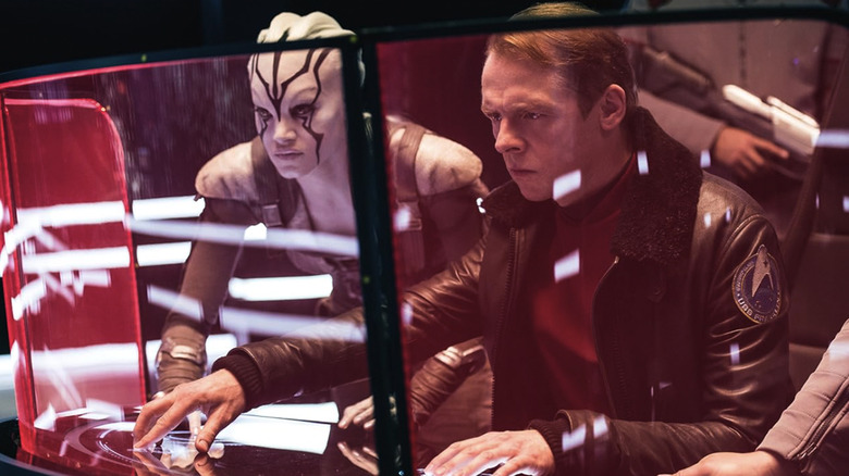Scotty works a computer while an alien looks on in Star Trek Beyond