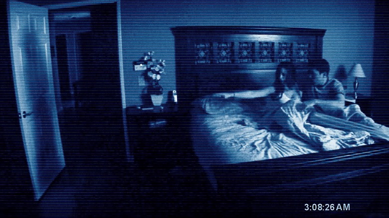 Katie Featherston and Micah Sloat looking at ghost shadow in doorway in Paranormal Activity 