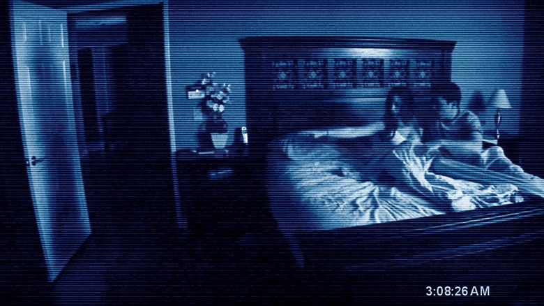 Katie Featherston and Micah Sloat looking at ghost shadow in doorway in Paranormal Activity