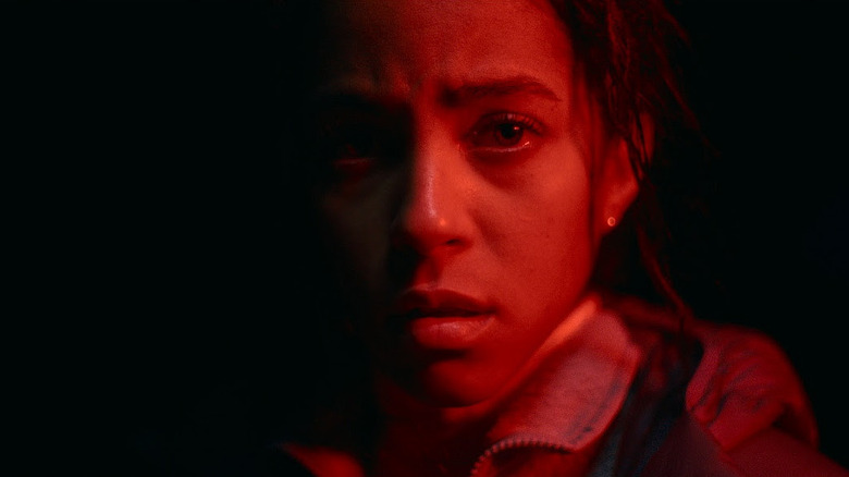 Maddie lit by red light in Passenger (2026)