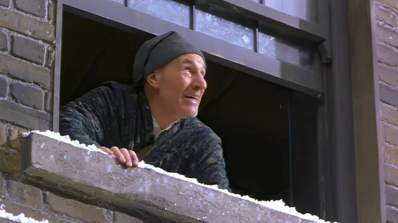 Ebenezer Scrooge happy, looking out the window in the 1999 version of A Christmas Carol