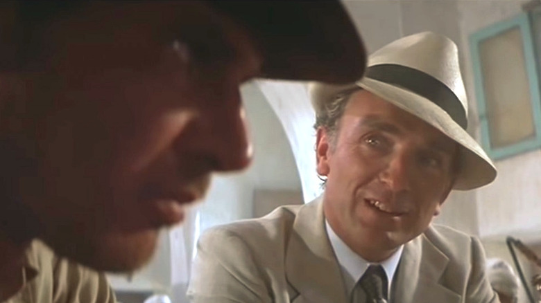 Belloq sitting with Indiana Jones in "Raiders of the Lost Ark"