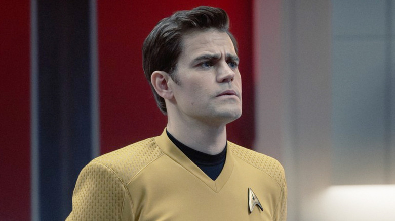 Paul Wesley as James T. Kirk standing at attention on the bridge of a starship in Star Trek: Strange New Worlds