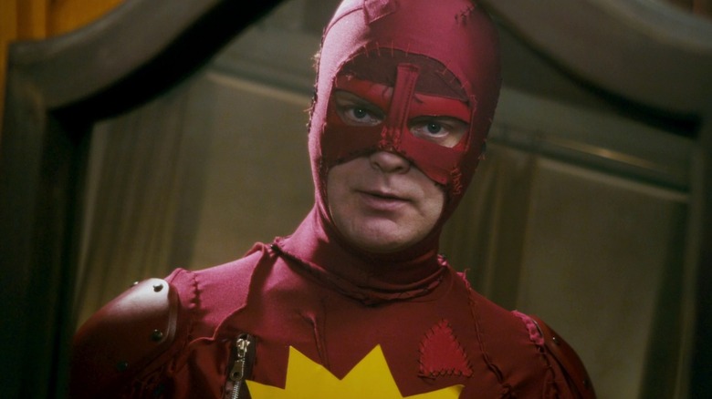 Rainn Wilson as Frank Darbo in his Crimson Bolt costume looking in the mirror in Super
