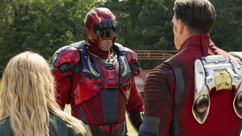 David Denman Keith Smith wears Captain Trimph Armor while the peacemaker faces John Cena and Jennifer Holland