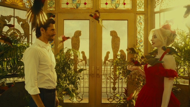 Juan Diego Botto como presidente general Silvio Luna e Margot Robbie como Harley Quinn, cercado por pássaros em um belo aviário no esquadrão suicida