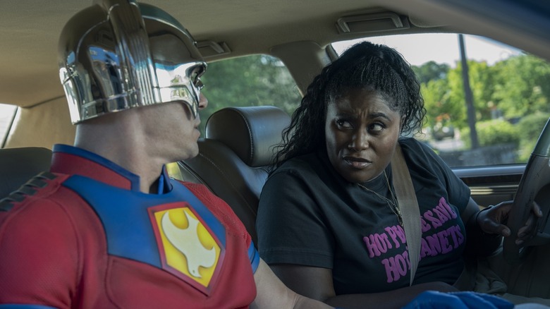 John Cena as Peacemaker talking to Danielle Brooks as Leota Adebayo in her car on Peacemaker season 2