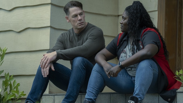 John Cena as Peacemaker and Danielle Brooks as Leota Adebayo sitting together in Peacemaker