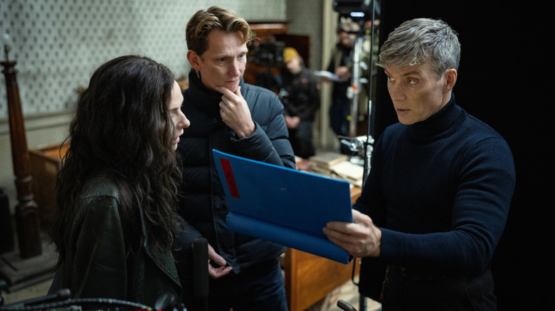 Director Tom Harper talking to actors Cillian Murphy as Tommy Shelby and Rebecca Ferguson as Kaulo on the set of Peaky Blinders: The Immortal Man