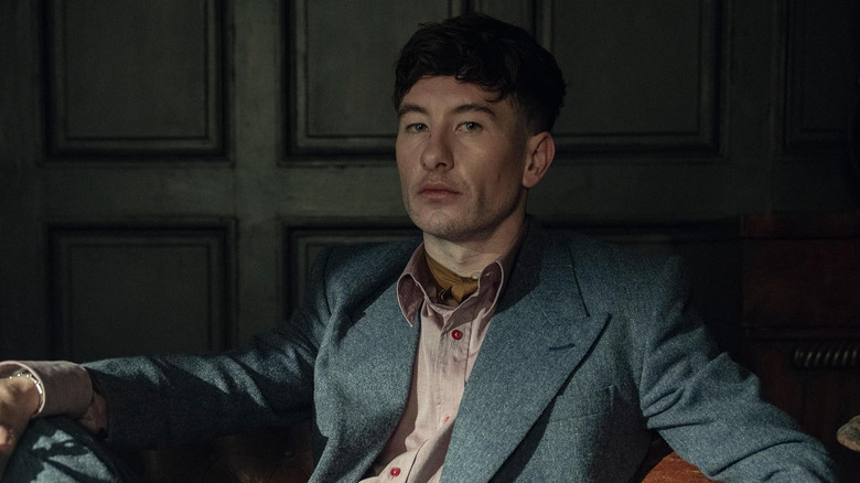 Duke Shelby holds a gun and sits in a leather chair in Peaky Blinders: The Immortal Man