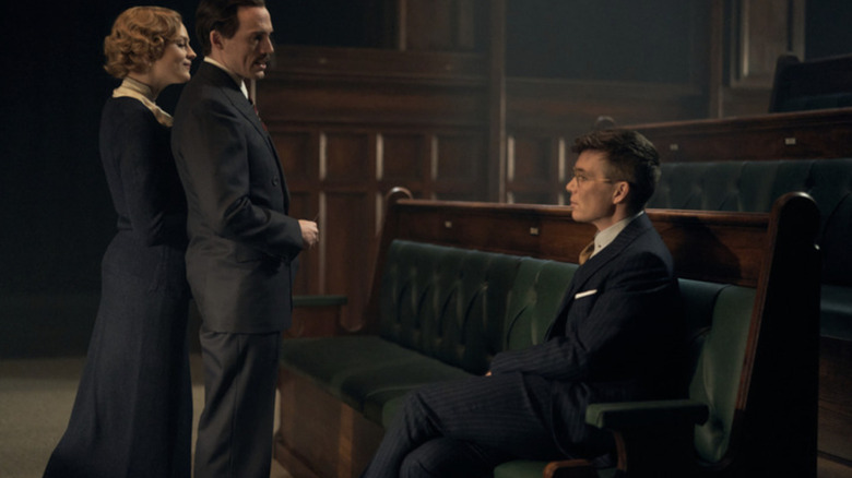 Amber Anderson as Diana Mitford and Sam Claflin as Oswald Mosley standing in the House of Commons opposite of Cillian Murphy as Tommy Shelby in Peaky Blinders