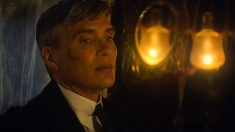 Cillian Murphy als Tommy Shelby in een donkere kamer met twee kaarsen achter hem in Peaky Blinders: The Immortal Man