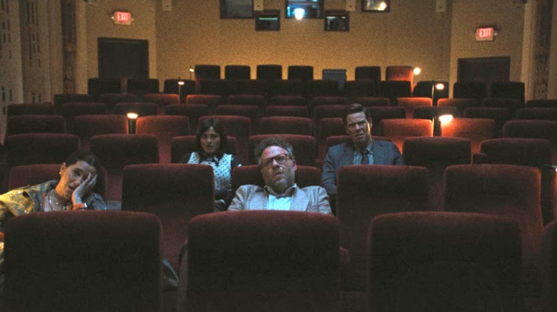 Don Draper watches a movie with a cigarette in his hand in Mad Men